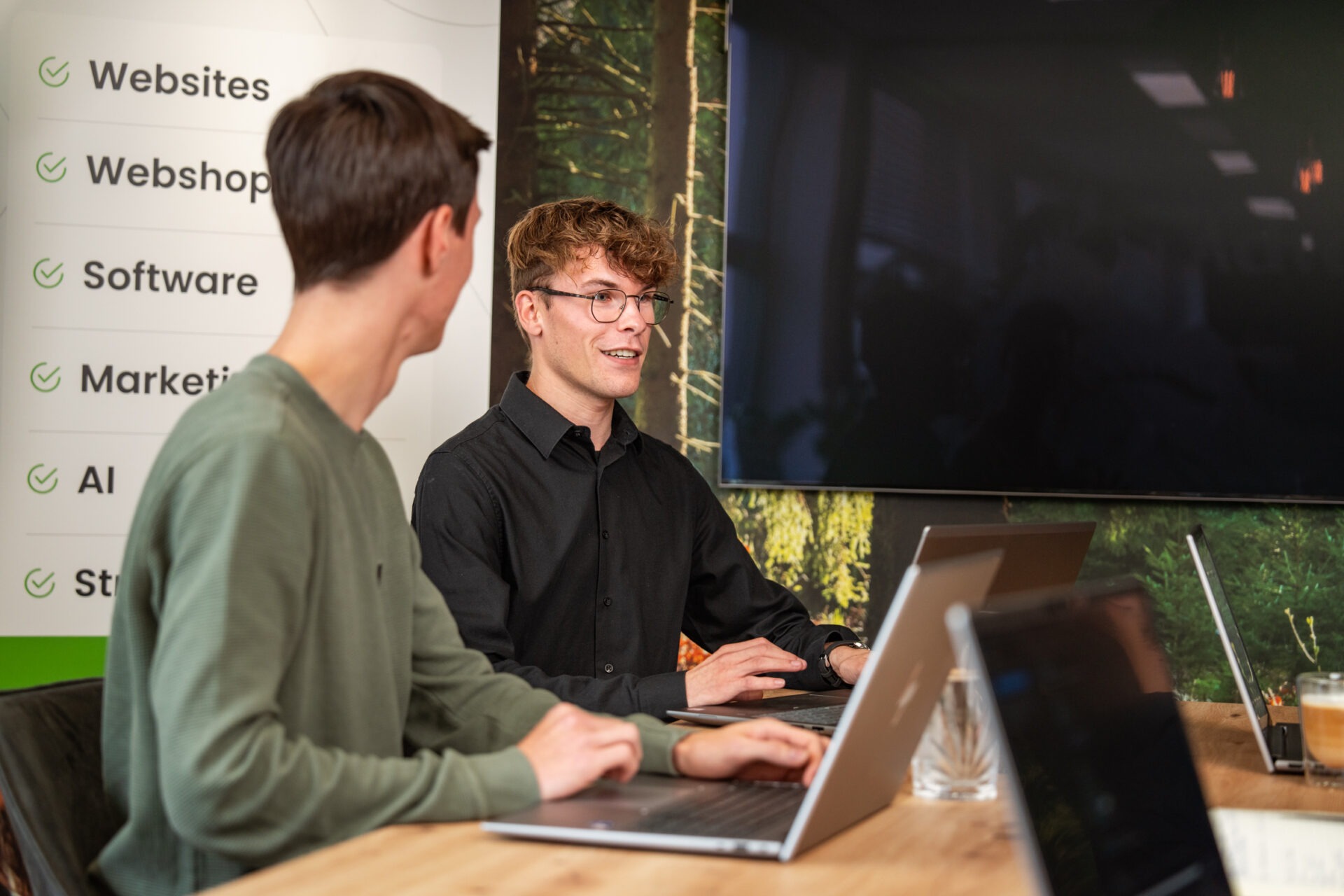 Twee medewerkers van Wux AI overleggen over data governance en de kosten van AI-investeringen.