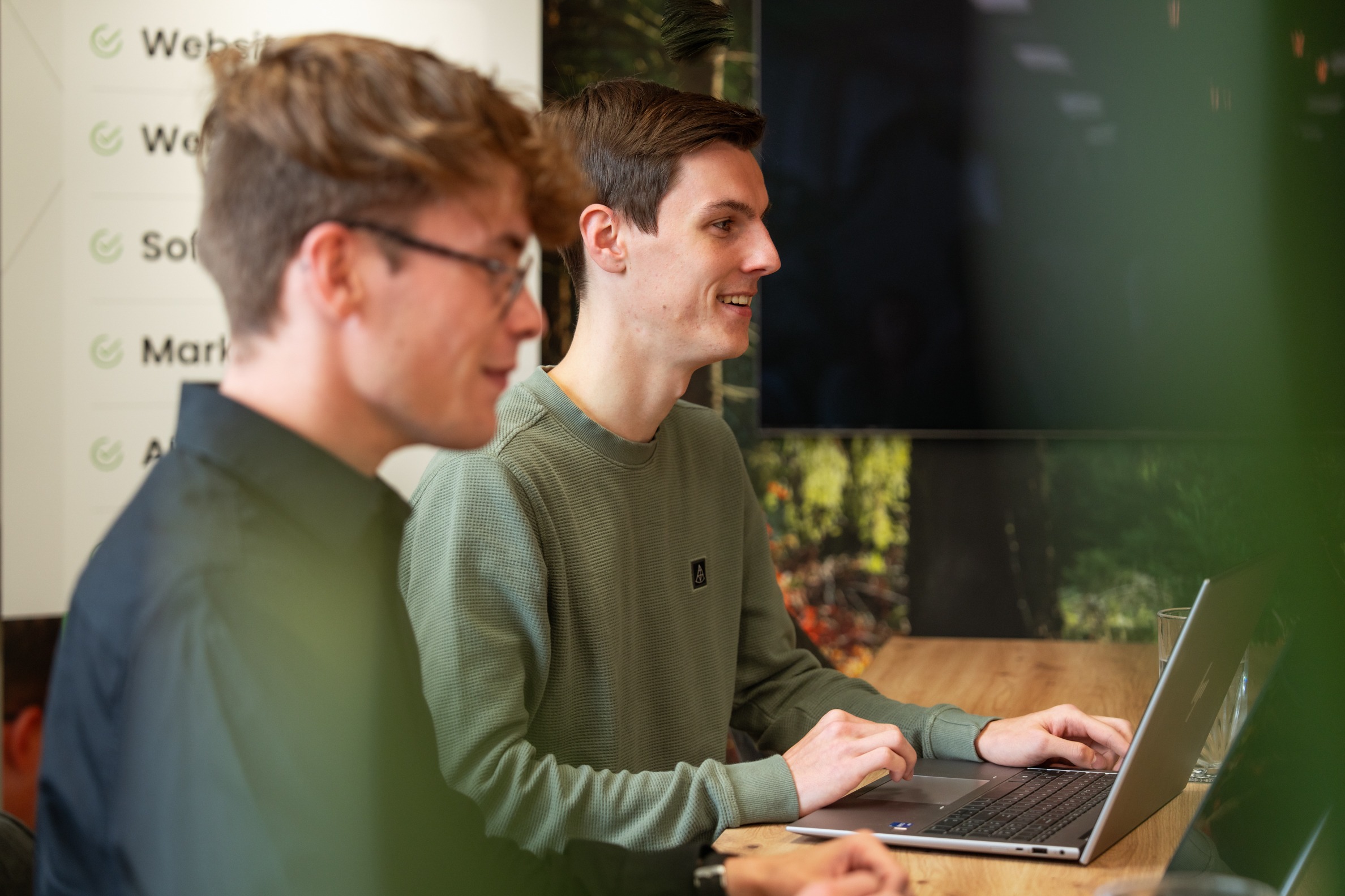 Twee medewerkers van Wux AI overleggen samen de inrichting van een interne AI-assistent.