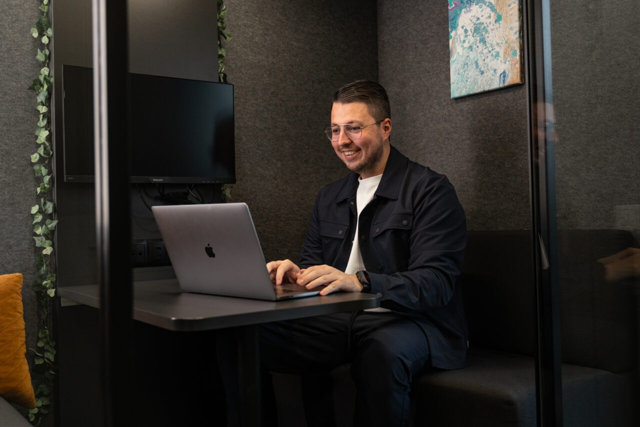 Een consultant van Wux AI berekent de exacte ROI en winst van AI op een laptop in een focusruimte.