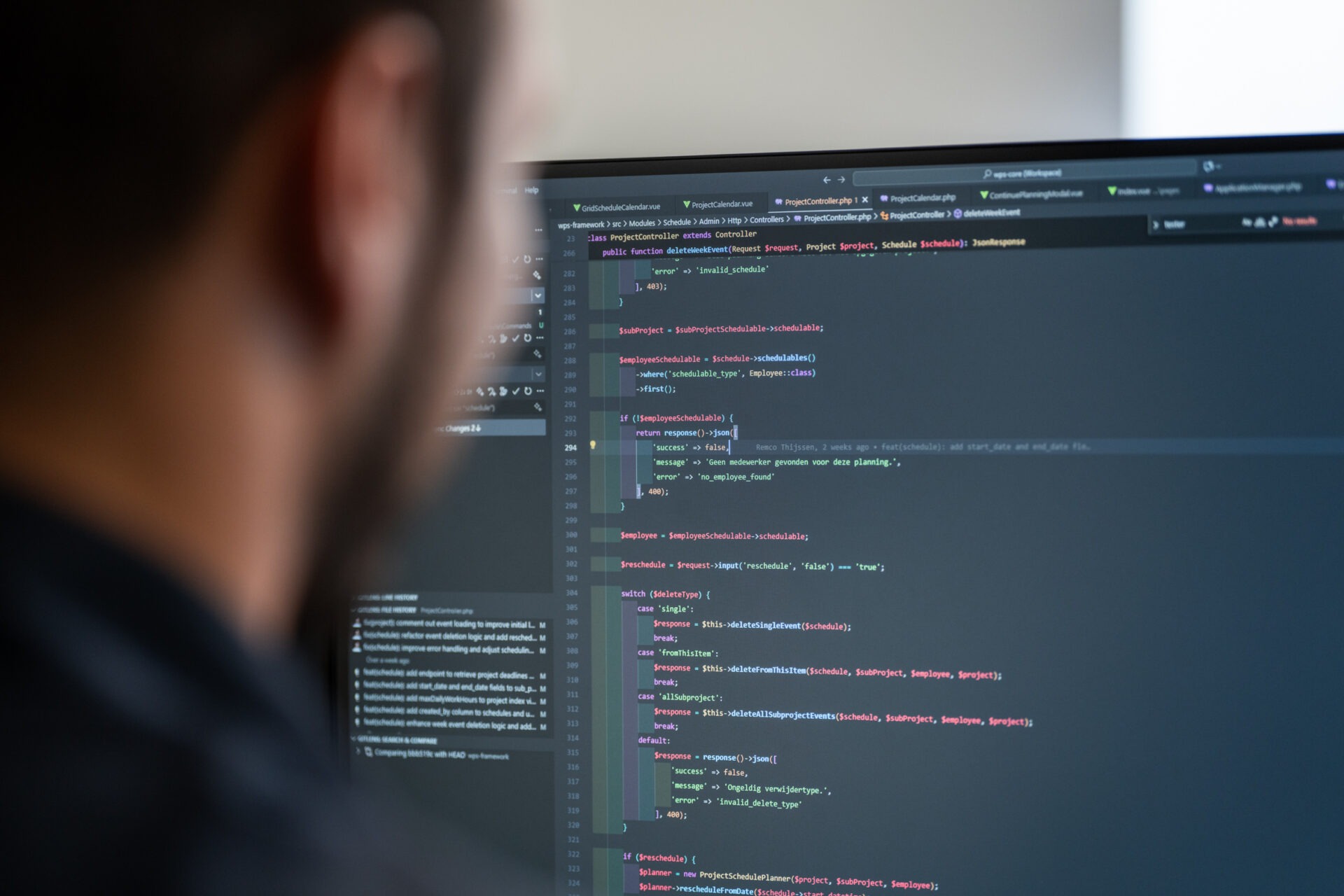 Een ontwikkelaar van Wux AI analyseert backend code op een monitor om een veilige AI-integratie te bouwen die voldoet aan de EU AI Act.