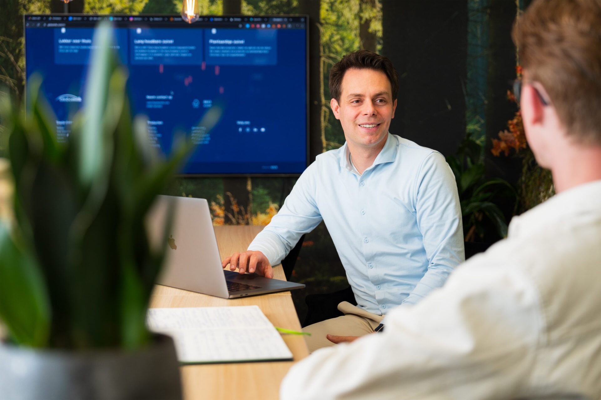 Wux AI-specialist bespreekt een AI-oplossing op scherm met klant