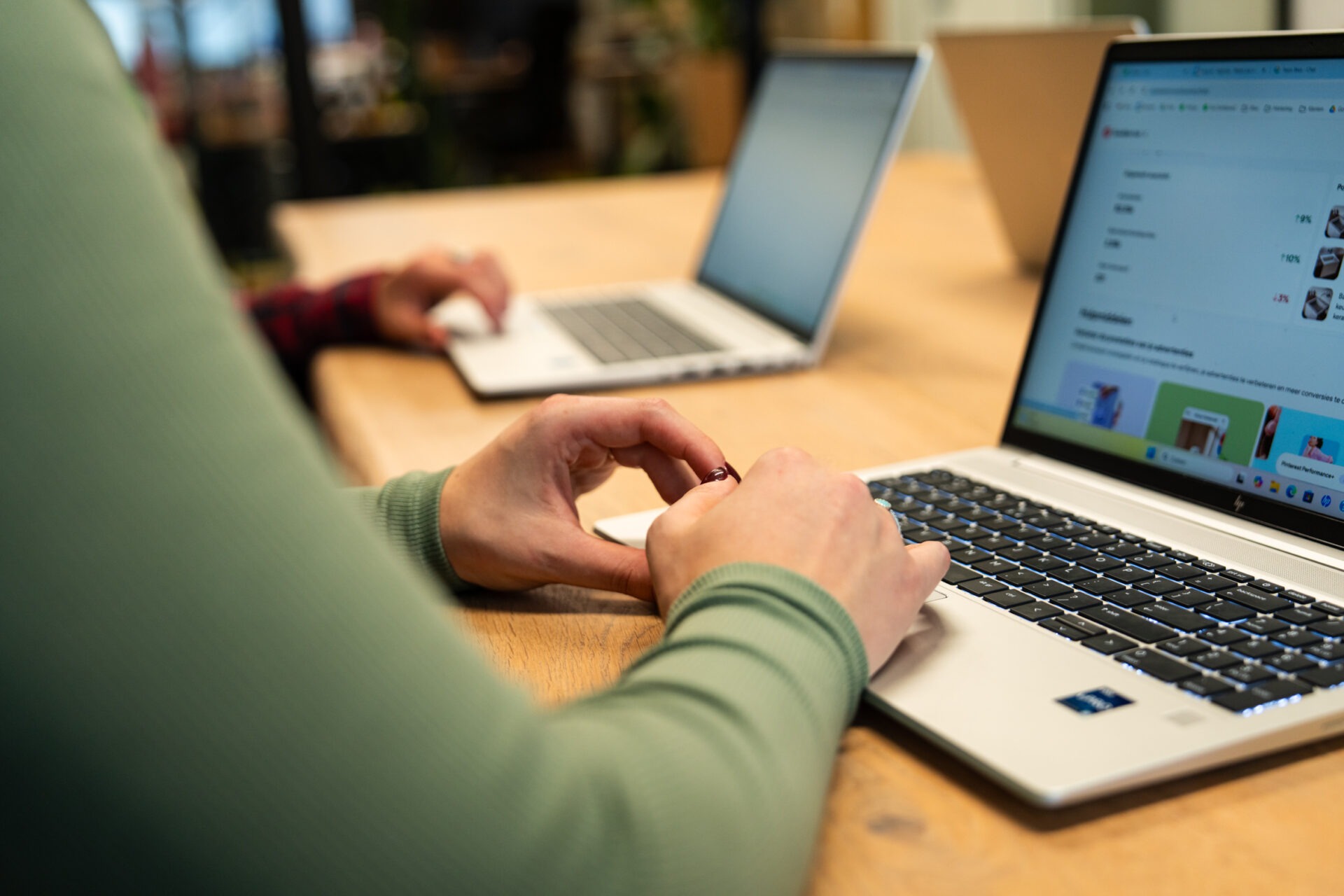 Medewerkers die laptops gebruiken voor het inrichten van efficiënte, AI-gestuurde workflows bij Wux AI.