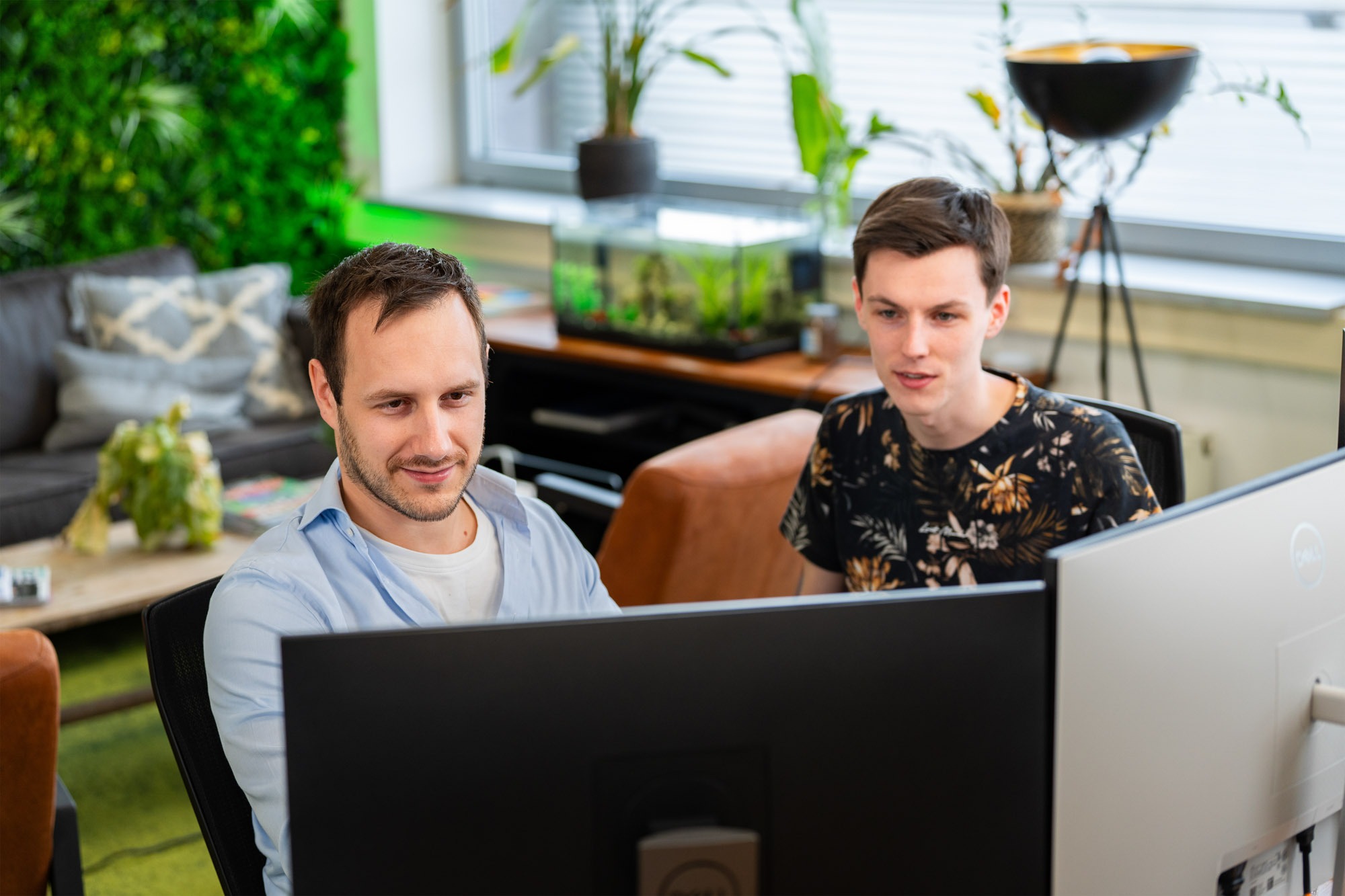 Medewerker van Wux AI werkt op kantoor achter een computer, ter illustratie van hoe AI-oplossingen de werkdruk verlagen.