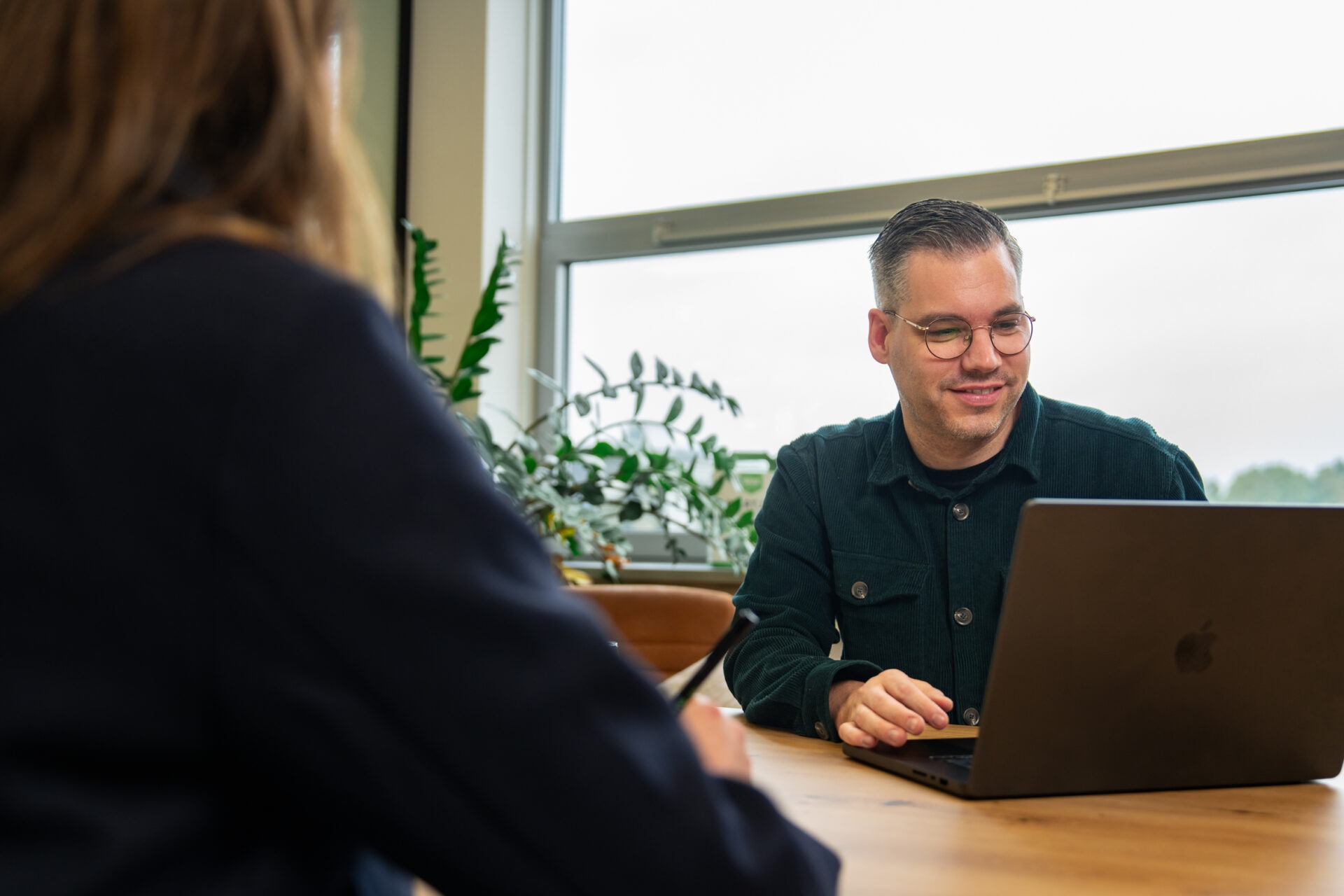 Wux AI-implementatiepartner in gesprek achter een laptop
